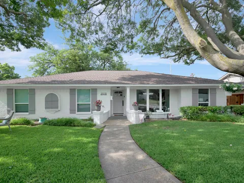 Single-story Dallas home with painted brick and a mature front tree