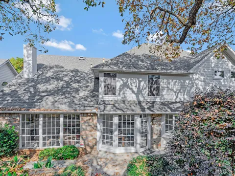 Older Park Cities house with painted trim under mature trees