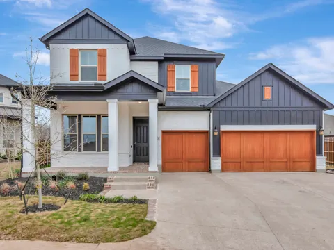 Keller family home with painted trim, shutters and a wood garage door