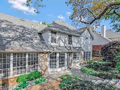 Trophy Club home with painted trim under mature trees