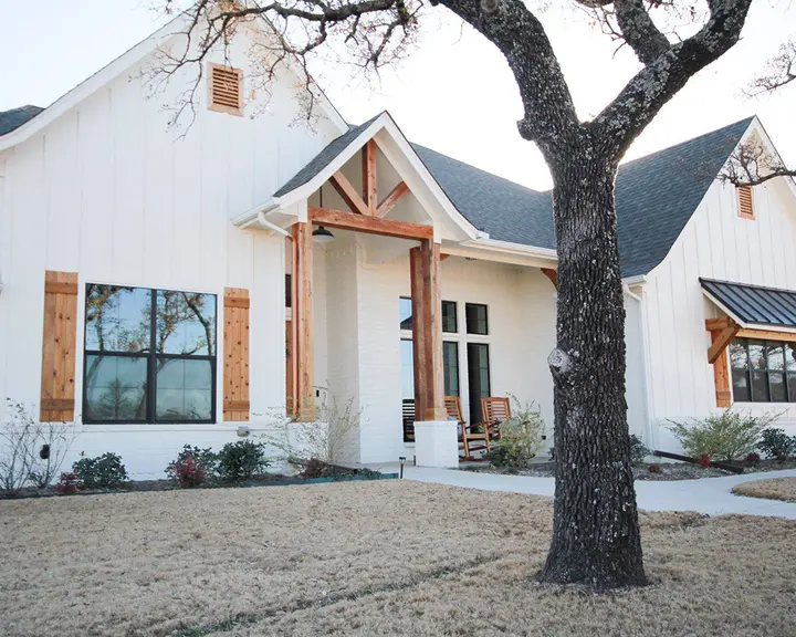 New-build envelope finished — siding, trim and timber — after