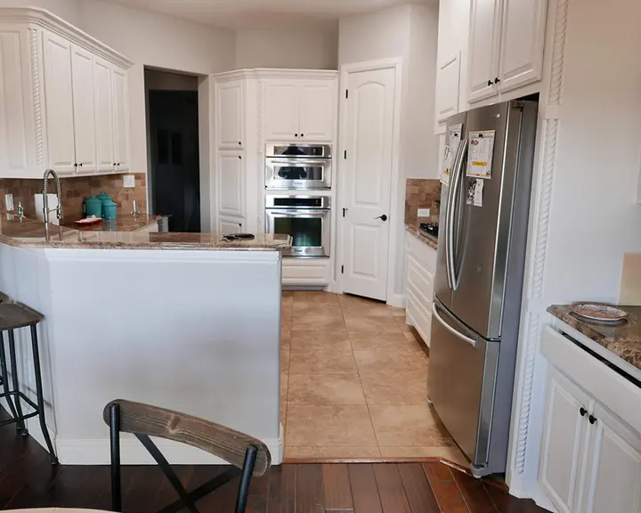 Dark cabinetry and built-in ovens brightened — after