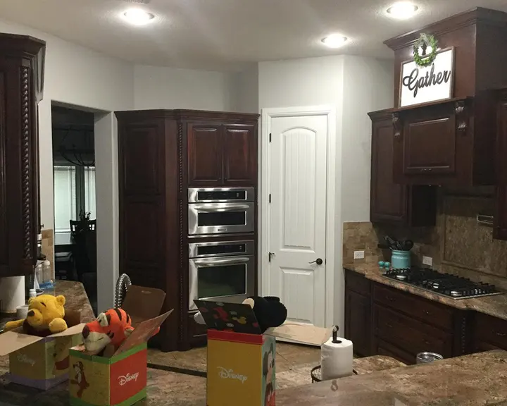Dark cabinetry and built-in ovens brightened — before