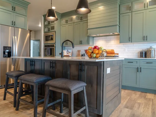 A kitchen with painted cabinetry and an island