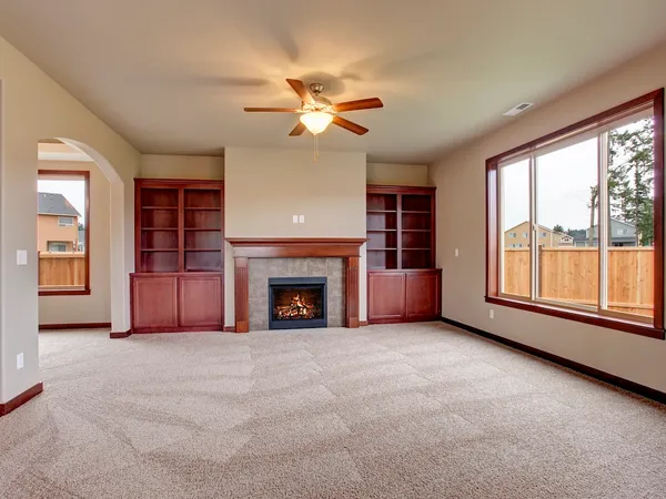 A painted living room with a fireplace and built-in shelving