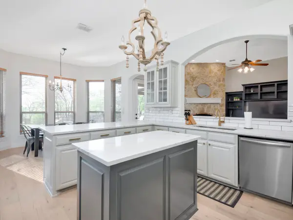 Painted kitchen cabinetry beneath an arched ceiling