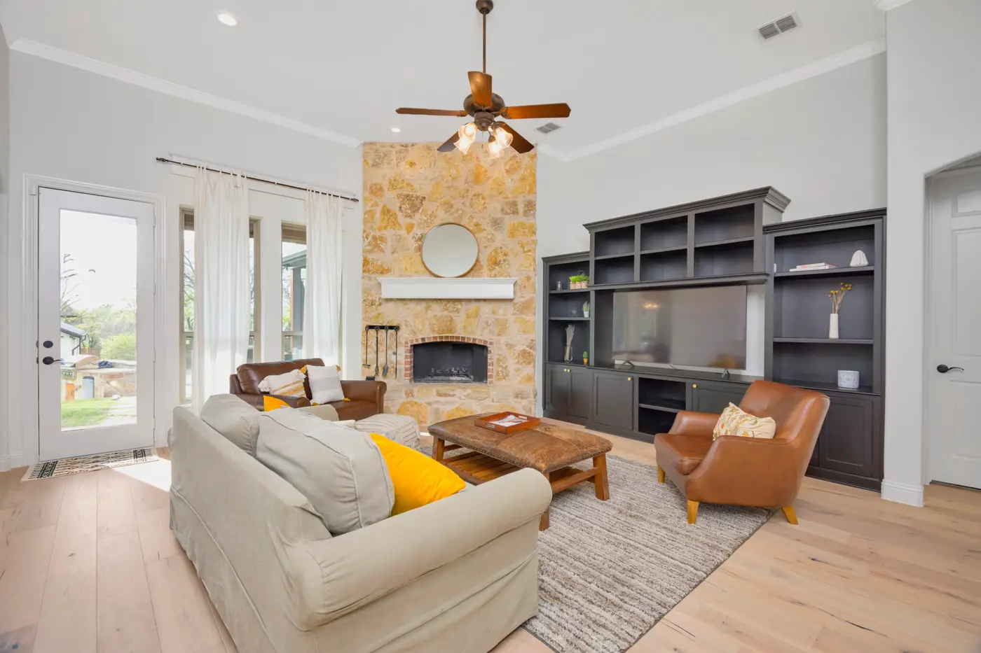 Living room repainted around a stone fireplace, with dark built-in shelving either side