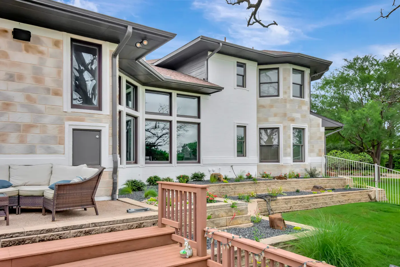 Stone and painted render elevation above a timber deck and tiered retaining walls