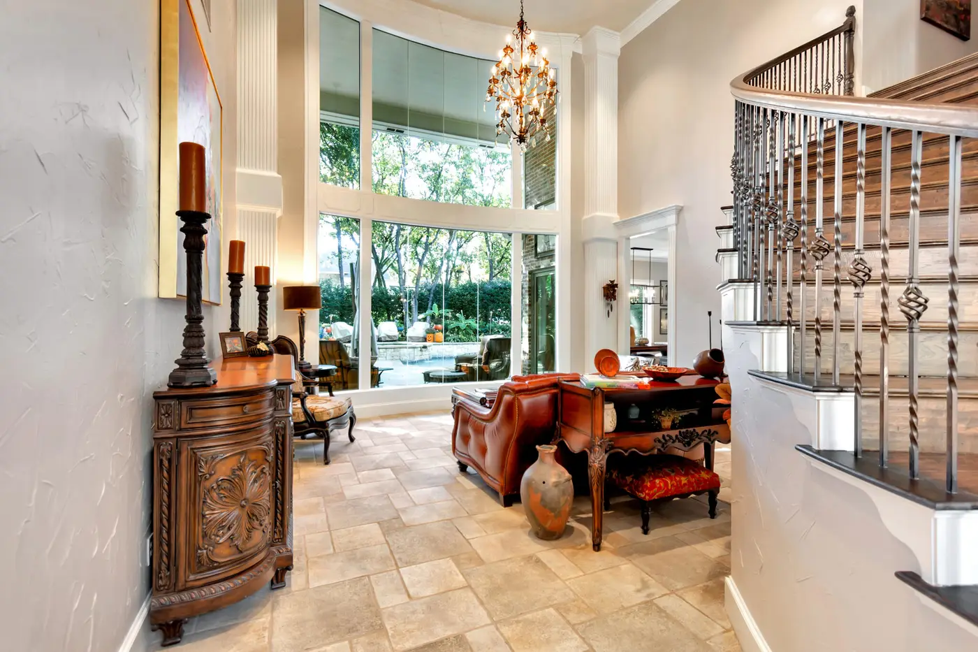 Double-height entry hall with painted walls, a stair balustrade and tall windows