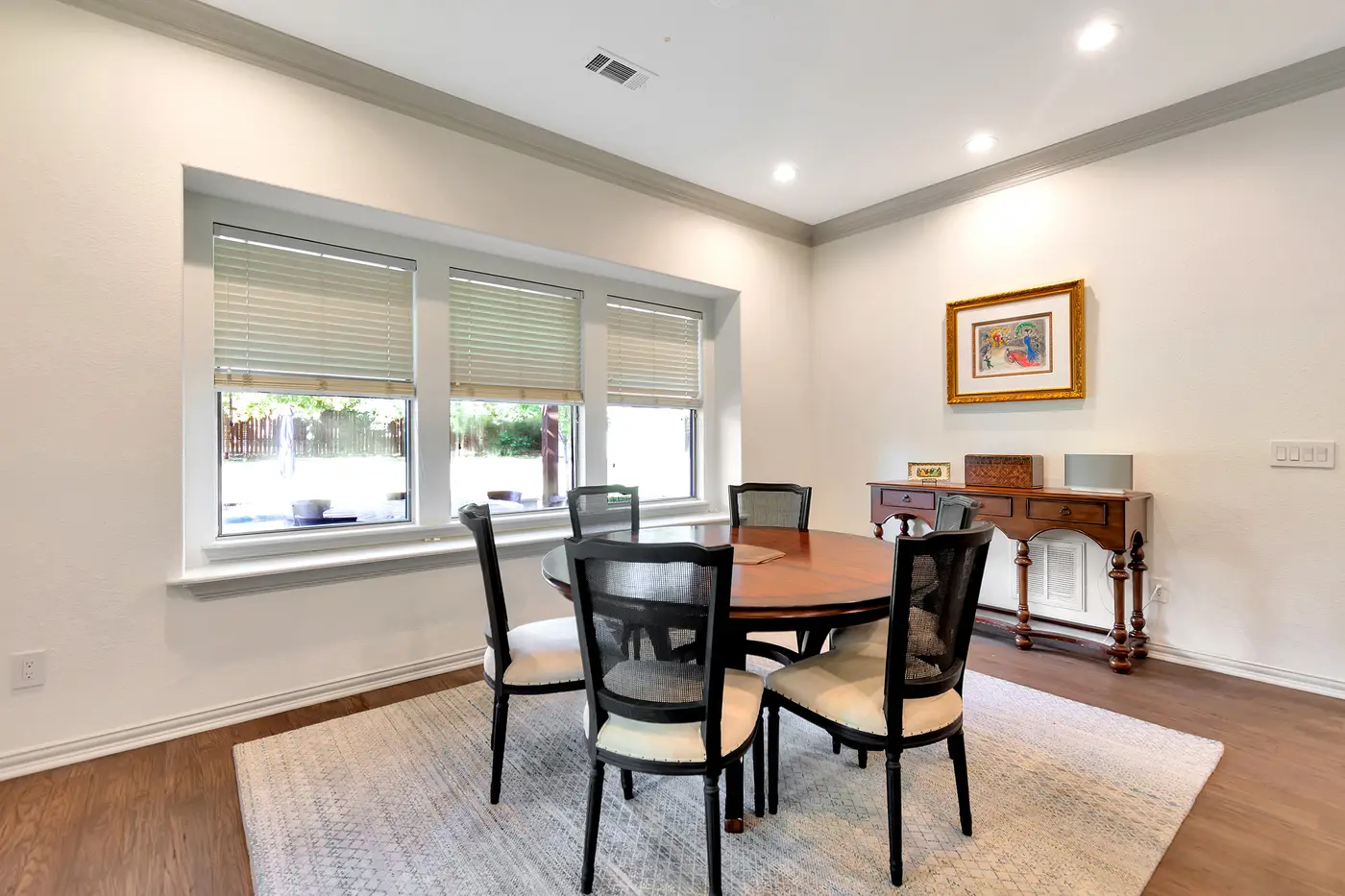 Dining room repainted in warm white, with a gray-painted window surround and cornice