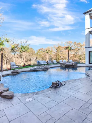 Rear elevation and pool of a large home after a full exterior repaint