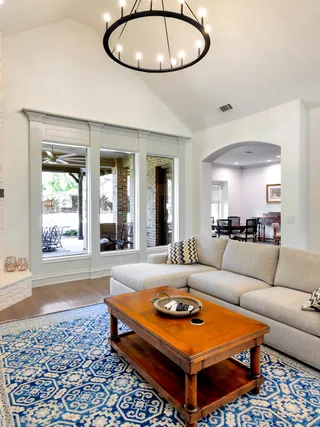 Vaulted living room with a stone fireplace, painted in a warm neutral