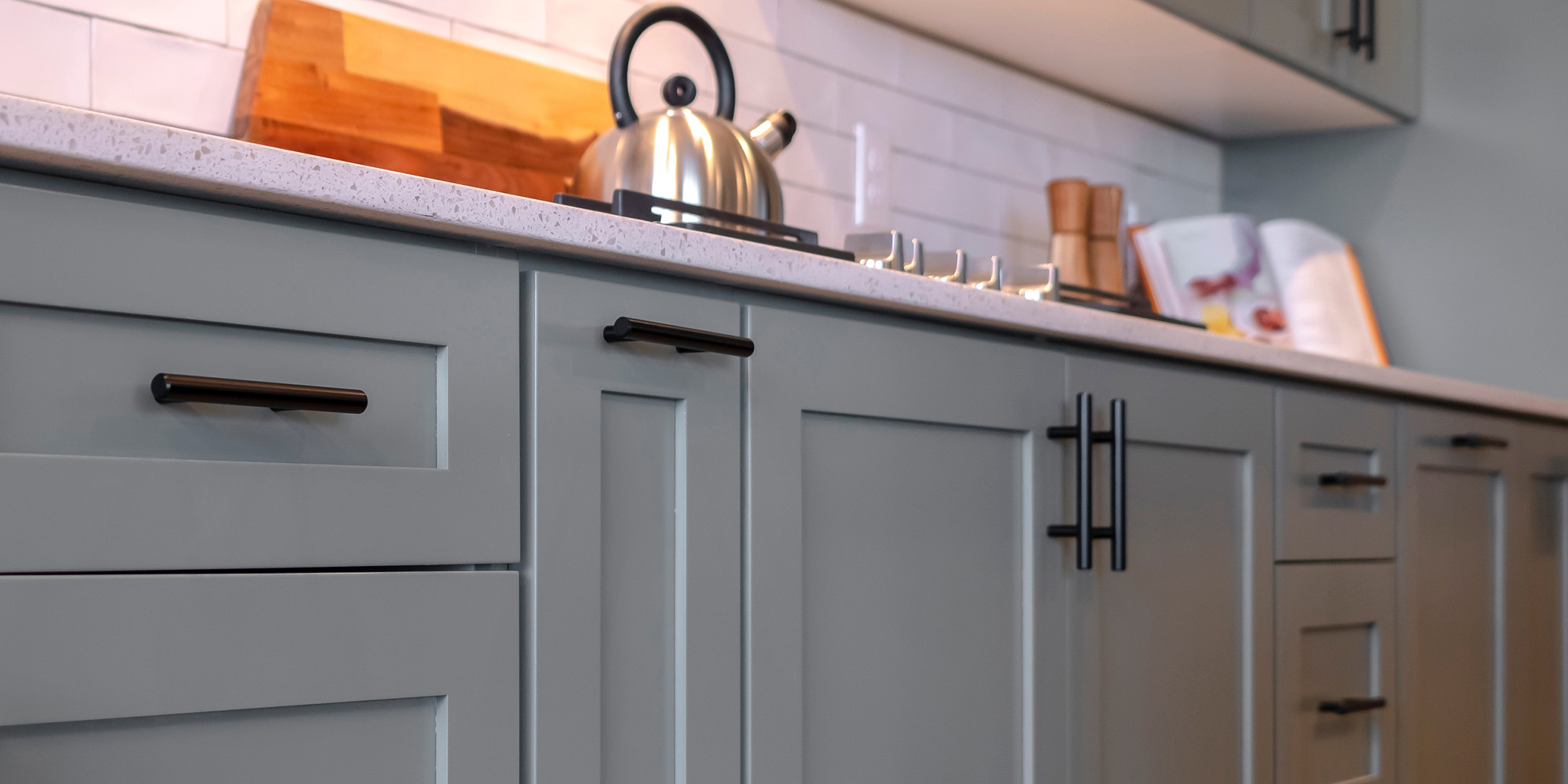 Photo Square Kitchen cabinets with white countertop black handles and tile backsplash